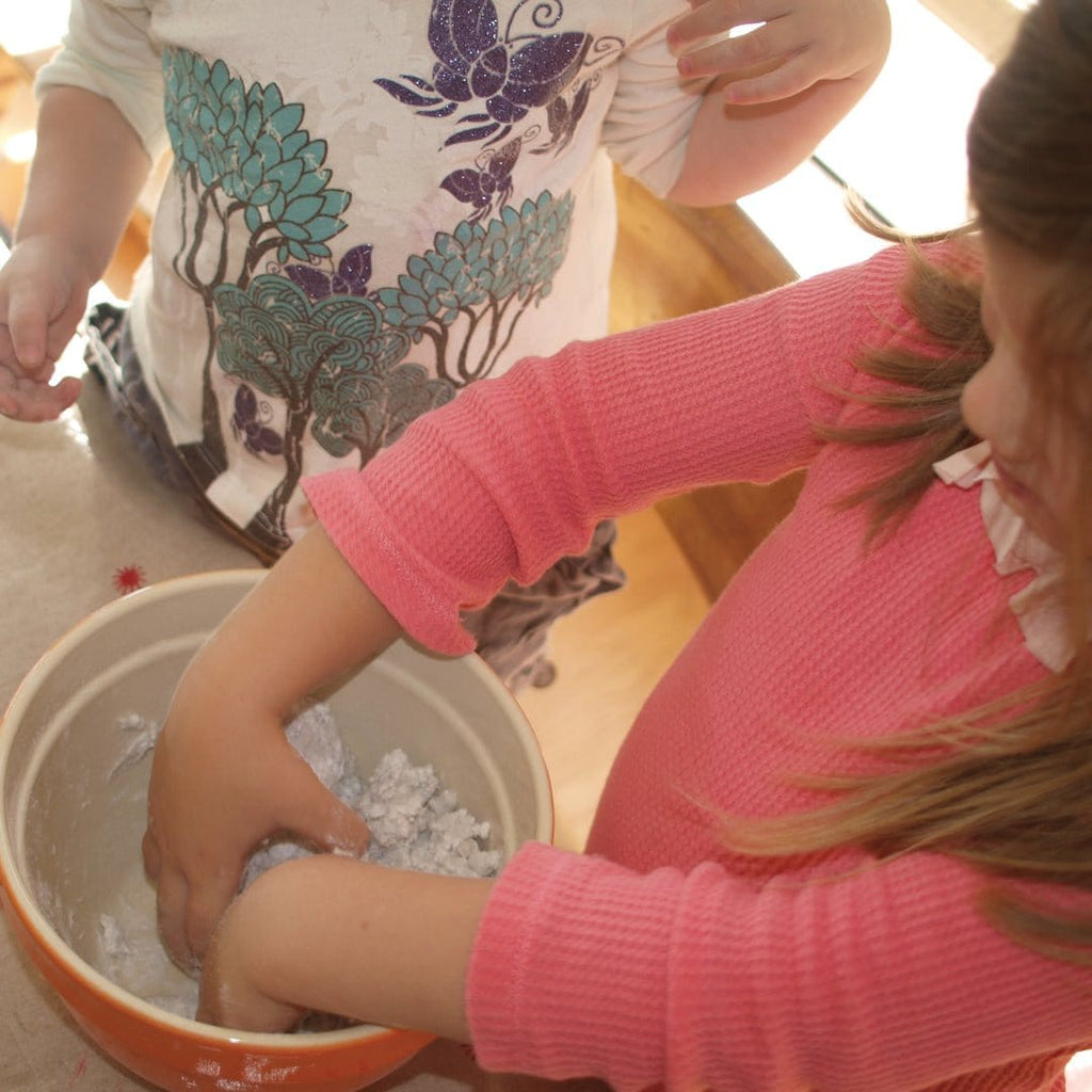 Children using a do it yourself kit to make a volcano with papier-mache and paint, engaging in a hands-on science project