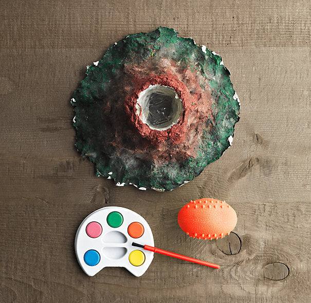 Do it Yourself kit volcano model with paint set and brush on wooden surface